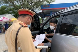Lực lượng cảnh sát giao thông kiểm tra giấy tờ lưu thông của các lái xe. (Ảnh: Nguyễn Văn Cảnh/TTXVN)