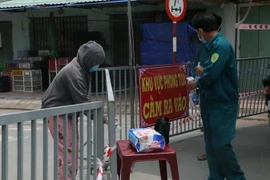 Đưa nhu yếu phẩm cho người dân trong khu vực cách ly. (Ảnh: Thanh Bình/TTXVN)