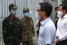 Phó Thủ tướng Vũ Đức Đam thăm hỏi chiến sĩ quân đội làm nhiệm vụ hỗ trợ người dân tại khu vực cách ly phong tỏa Phường Tân Chánh Hiệp, quận 12. (Ảnh: Xuân Tình/TTXVN)