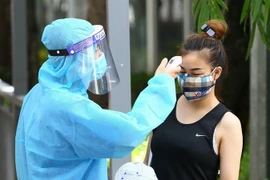 Tất cả bệnh nhân và người nhà khi vào bệnh viện sẽ được kiểm tra thân nhiệt và khai báo y tế. (Ảnh: Minh Quyết/TTXVN)