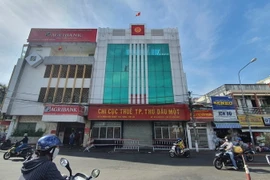 Trung tâm Y tế thành phố Thủ Dầu Một đã triển khai phong tỏa, phun khử khuẩn toàn bộ Chi cục Thuế. (Ảnh: Văn Hướng/TTXVN)
