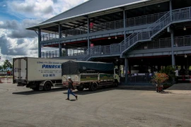 Các xe tải chờ làm thủ tục vào thành phố Cần Thơ giao nhận hàng hóa tại điểm kiểm soát ở Bến xe Trung tâm thành phố. (Ảnh: Thanh Liêm/TTXVN)