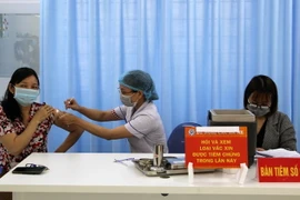 Những người tham gia các tổ phòng chống COVID-19 tại cộng đồng cũng được tiêm phòng đợt này. (Ảnh: Xuân Triệu/TTXVN)