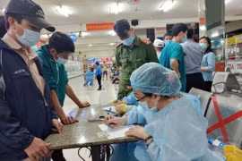 Nhân viên Trung tâm Y tế quận Bình Thạnh, TP.HCM chuẩn bị lấy mẫu xét nghiệm tại Bến xe Miền Đông. (Ảnh: TTXVN phát)