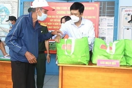 Bí thư Huyện ủy Xuân Lộc Viên Hồng Tiến (áo trắng ) trao quà hỗ trợ cho người dân khó khăn trong đại dịch. (Ảnh: TTXVN phát)