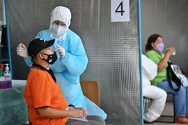 Nhân viên y tế lấy mẫu xét nghiệm COVID-19 tại Bangkok, Thái Lan. (Ảnh: AFP/TTXVN)