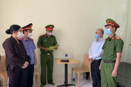 Lực lượng công an đọc các quyết định khởi tố vụ án. (Ảnh: TTXVN phát)