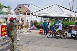 Người dân trong địa phương đi ra ngoài đường phải có lý do chính đáng và cấp thiết. (Ảnh: Hữu Chí/TTXVN)