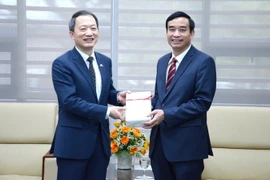 Phó chủ tịch UBND thành phố Đà Nẵng Lê Trung Chinh nhận quà từ Tổng lãnh sự Hàn Quốc tại Đà Nẵng Ahn Minh Sik. (Ảnh: Quốc Dũng/TTXVN)