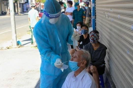 Lấy mẫu xét nghiệm SARS-CoV-2 cho người dân trên địa bàn Đà Nẵng trong ngày đầu thực hiện 'ai ở đâu thì ở đó.' (Ảnh: Trần Lê Lâm/TTXVN)