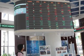 Nhà đầu tư theo dõi bảng giá chứng khoán tại sàn HOSE. (Ảnh: Hứa Chung/TTXVN)