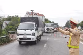 Cảnh sát giao thông kiểm soát phương tiện tại chốt kiểm soát. (Ảnh: Hoàng Hùng/TTXVN)