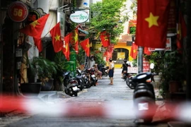 Nhân dân treo cờ Tổ quốc kỷ niệm Ngày Giải phóng Thủ đô. (Ảnh: Thành Đạt/TTXVN)