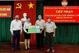 Đại diện Ngân hàng Vietcombank chi nhánh An Giang trao 50 triệu đồng ủng hộ quỹ Phòng, chống dịch COVID-19 tỉnh An Giang. (Ảnh: Thanh Sang/TTXVN)
