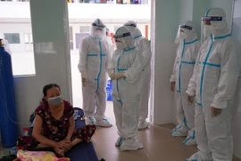 Đoàn công tác thăm hỏi, động viện và hỗ trợ sữa, thuốc điều trị cho bệnh nhân COVID-19. (Ảnh: TTXVN)