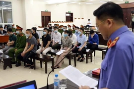 Đại diện Viện Kiểm sát đọc bản cáo trạng luận tội các bị cáo tại phiên tòa. (Ảnh: Phạm Kiên/TTXVN)