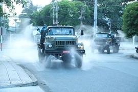 Tiểu đoàn Hóa học 38 (Bộ Tham mưu) và lực lượng Quân y (Cục Hậu cần) thuộc Quân đoàn 4 phun xịt khử khuẩn ở tỉnh Bình Dương. (Ảnh: Văn Hướng-Tuấn Anh/TTXVN)