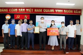 Ông Nguyễn Thành Trung, Phó Chủ tịch Thường trực Ủy ban MTTQ Việt Nam Thành phố trao cho ông Nguyễn Thế Hiệp, Phó Chủ tịch Ủy ban MTTQ Việt Nam tỉnh Thái Bình bức thư cảm ơn. (Ảnh: Xuân Khu/TTXVN)