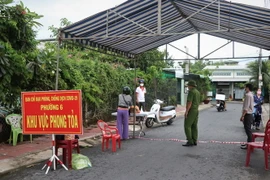 Chốt kiểm soát và hướng dẫn người dân trong khu vực phong tỏa đảm bảo các biện pháp an toàn phòng dịch. (Ảnh: Huỳnh Anh/TTXVN)