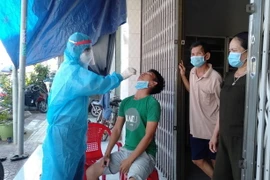 Lực lượng chức năng triển khai test nhanh COVID-19 đối với người dân ở phường Tam Quan Bắc, thị xã Hoài Nhơn. (Ảnh: TTXVN phát)