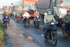 Người dân ở Tiền Giang thực hiện nghiêm túc đeo khẩu trang khi ra đường. (Ảnh: Minh Trí/TTXVN)