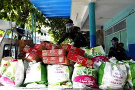 Cán bộ chiến sỹ Trung đoàn 1, Sư đoàn 9, Quân đoàn 4 vận chuyển hàng ngàn túi quà an sinh xã hội trợ giúp người nghèo, hộ gia đình có hoàn cảnh khó khăn ở các phường trong những ngày thành phố giãn cách xã hội “ai ở đâu, ở yên đấy.” (Ảnh: Thanh Vũ/TTXVN)