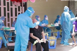 Lực lượng thanh niên tình nguyện thuộc Tỉnh đoàn Bình Dương phối hợp lấy mẫu tìm F0 tại 11 phường đang được khóa chặt ở Bình Dương do F0 quá nhiều. (Ảnh: Chí Tưởng/TTXVN)