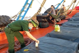 Lực lượng Biên phòng kiểm tra và niêm phong số dầu vận chuyển không có hóa đơn, chứng từ hợp pháp. (Ảnh: TTXVN phát)
