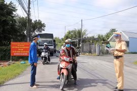 Kiểm soát người ra vào địa bàn tại chốt kiểm soát dịch bệnh ở xã Hậu Thành, huyện Cái Bè, tỉnh Tiền Giang. (Ảnh: Hữu Chí/TTXVN)