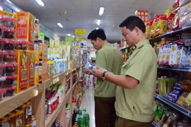 Lực lượng Quản lý thị trường kiểm tra các sản phẩm hàng hóa. (Ảnh: Phạm Kiên/TTXVN)