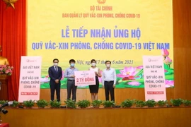 Công ty TNHH Bảo hiểm nhân thọ AIA Việt Nam trao tượng trưng số tiền ủng hộ Quỹ vaccine phòng, chống COVID-19 Việt Nam. (Ảnh: Hoàng Hiếu/TTXVN)