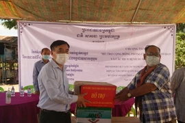 Công sứ sứ quán Việt Nam tại Campuchia Lại Xuân Chiến (trái) trao tặng vật tư y tế chống dịch cho đại diện chính quyền hai xã Saeb và Ta Ches, huyện Kampong Trolach. (Ảnh: Trần Long/TTXVN)
