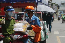 Lực lượng Công an và dân quân phường 11, quận Bình Thạnh trực kiểm soát tại chốt ngã tư đường Lê Quang Định-Phan Văn Đậu. (Ảnh: Thanh Vũ/TTXVN)
