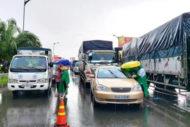 Xe ôtô được hướng dẫn phân luồng chờ kiểm tra, khai báo y tế trước khi vào thành phố Cần Thơ. (Ảnh: Thu Hiền/TTXVN)