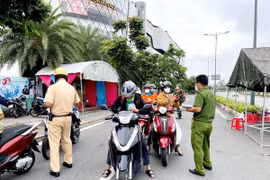 Lực lượng Công an tại chốt kiểm trên đường Phạm Văn Đồng, phường Hiệp Bình Chánh, Thủ Đức, kiểm tra giấy tờ của người lưu thông. (Ảnh: Thành Chung/TTXVN)