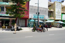 Lực lượng Công an thành phố Tây Ninh tuần tra, lập chốt di động kiểm soát người đi đường không có lý do chính đáng. (Ảnh: Thanh Tân/TTXVN)