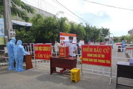 Cử tri vùng cách ly y tế trong khu dân cư ở khu vực phong tỏa, tham gia bỏ phiếu bầu cử. (Ảnh: Duy Khương/TTXVN)