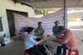 Lực lượng chức năng làm việc với đối tượng liên quan đến hành vi cung cấp, chia sẻ thông tin xúc phạm uy tín cơ quan, tổ chức. (Ảnh: Phan Quân/TTXVN)