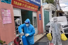  Lực lượng Quân y tại Trạm y tế lưu động mang các đồ dùng cần thiết để đến nhà F0. (Ảnh: Mạnh Linh/TTXVN)