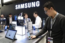 Khách hàng tìm hiểu các sản phẩm điện thoại thông minh của Samsung tại Triển lãm Thế giới di động ở Barcelona, Tây Ban Nha. (Ảnh: AFP/TTXVN)