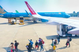 Hành khách đeo khẩu trang trước khi lên tàu bay tại Cảng hàng không Thọ Xuân, tỉnh Thanh Hóa. (Ảnh: Duy Khương/TTXVN)