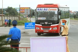 Các lực lượng liên ngành hướng các phương tiện giao thông vào Chốt kiểm kiểm soát dịch bệnh tại chốt huyện Vĩnh Bảo trước khi vào thành phố Hải Phòng. (Ảnh: An Đăng/TTXVN)