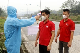 Người dân và hành khách được kiểm tra thân nhiệt tại chốt nút giao đường cao tốc Nội Bài-Lào Cai thuộc địa phận xã Xuân Giao, huyện Bảo Thắng (Km234). (Ảnh: Quốc Khánh/TTXVN)