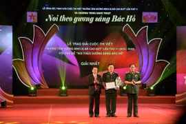 Thượng tướng Võ Trọng Việt và Thượng tướng Trần Quang Phương trao hoa và bằng chứng nhận cho tác giả đoạt giải Nhất. (Nguồn: qdnd.vn)