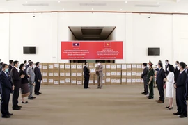 Quang cảnh lễ bàn giao hàng viện trợ của Chính phủ Việt Nam cho Chính phủ Lào để phòng chống dịch COVID-19. (Ảnh: Phạm Kiên/Vietnam+)