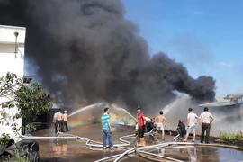 Lực lượng chữa cháy nỗ lực không chế ngọn lửa tại hiện trường. (Ảnh: Nguyễn Văn Việt/TTXVN)