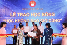 Phó Chủ tịch nước Đặng Thị Ngọc Thịnh và nguyên Phó Chủ tịch nước Nguyễn Thị Doan, Chủ tịch Hội Khuyến học Việt Nam trao học bổng và giấy chứng nhận của Chương trình học bổng cho những người lớn tuổi là tấm gương tự học xuất sắc. (Ảnh: Thanh Tùng/TTXVN)