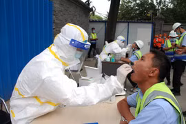 Nhân viên y tế lấy mẫu dịch xét nghiệm COVID-19 cho người dân tại Bắc Kinh, Trung Quốc ngày 17/6/2020. (Nguồn: THX/TTXVN)