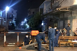 Lực lượng chức năng tiến hành dỡ bỏ các chốt kiểm soát cách ly 2 tuyến đường thuộc phường Đức Thắng, thành phố Phan Thiết (Bình Thuận). (Ảnh: Nguyễn Thanh/TTXVN)