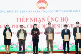Các doanh nghiệp, nhà hảo tâm nhận giấy chứng nhận đăng ký ủng hộ phòng chống dịch COVID-19. (Nguồn: TTXVN phát)